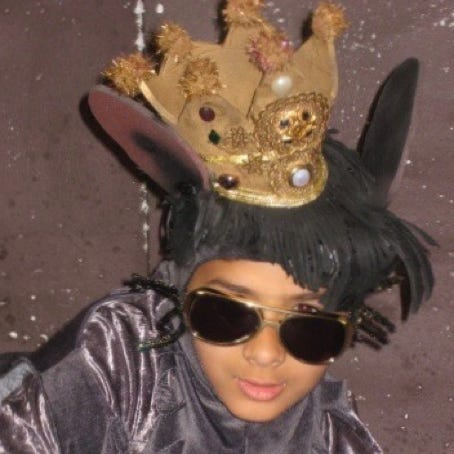 Boy in rat costume with crown and Elvis sunglasses